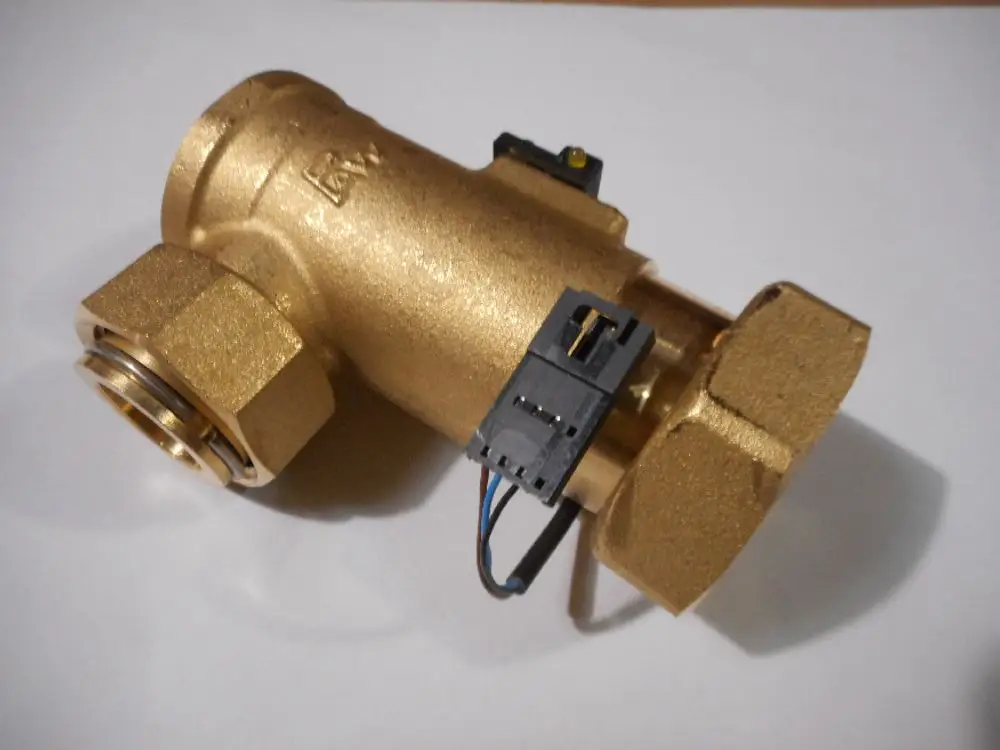 Goldfarbener Wasserflussregler von Remeha mit elektrischer Anschlussleitung. Deutlich erkennbare Anschlussgewinde und Anschluss für die elektronische Steuerung.